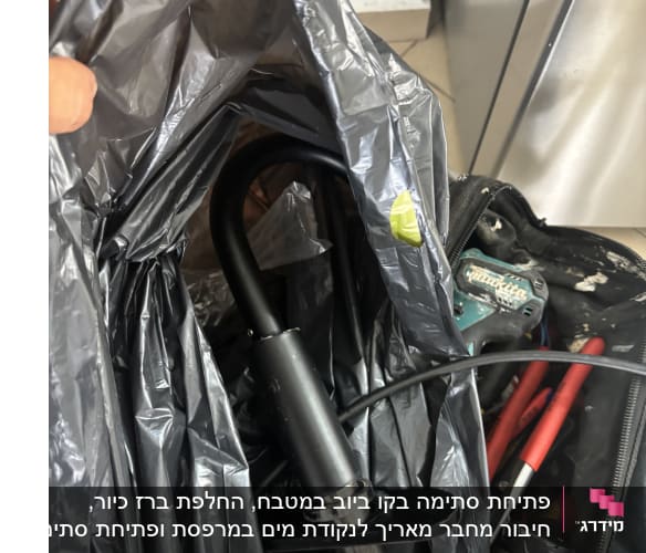 ברז וכלי עבודה בתיק פתוח על הרצפה